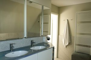 Bad mit Doppelwaschtisch und Natursteinoberflächen